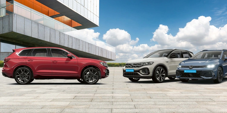 Drei moderne Autos vor Architektur.